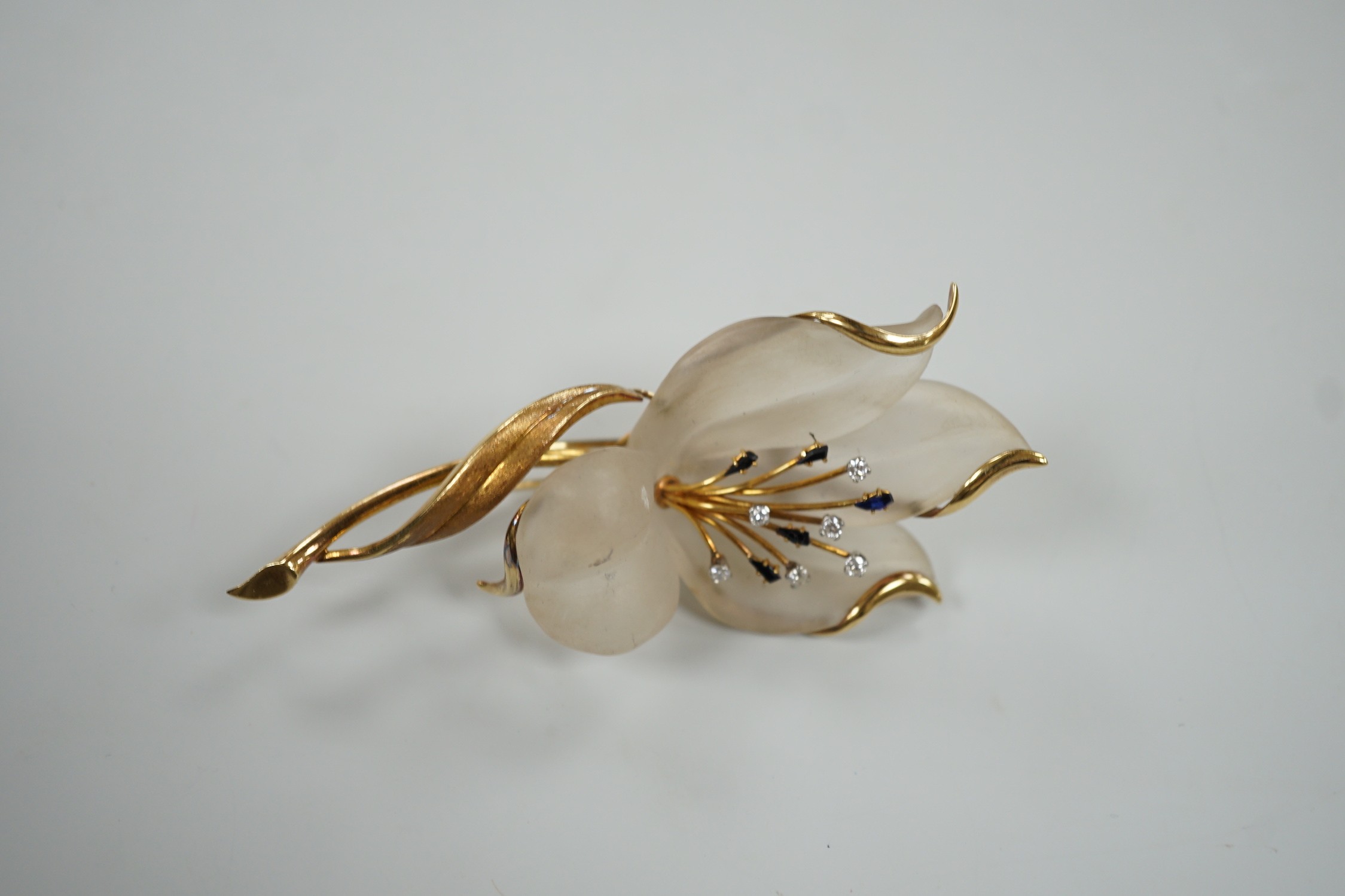A modern continental yellow metal, sapphire and diamond set frosted glass? flower clip brooch, 85mm, gross 25.8 grams.
